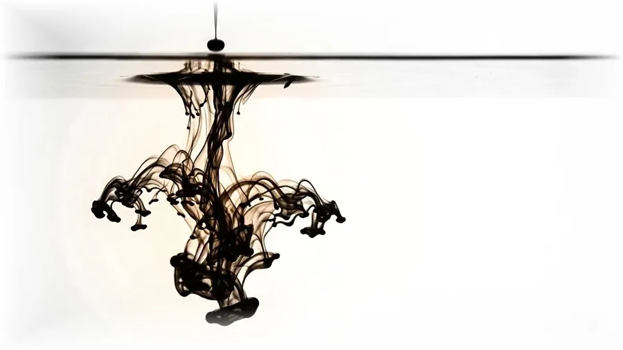 A drop of ink blooming downward in still water — the moment an idea takes shape